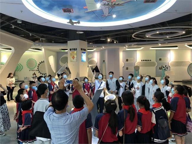 科技辅导员正在给小朋友讲解“光控飞机”展品