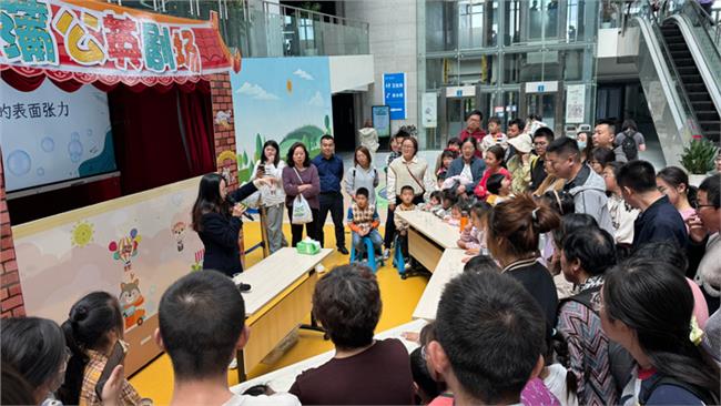 科技辅导员在展示回形针漂浮实验